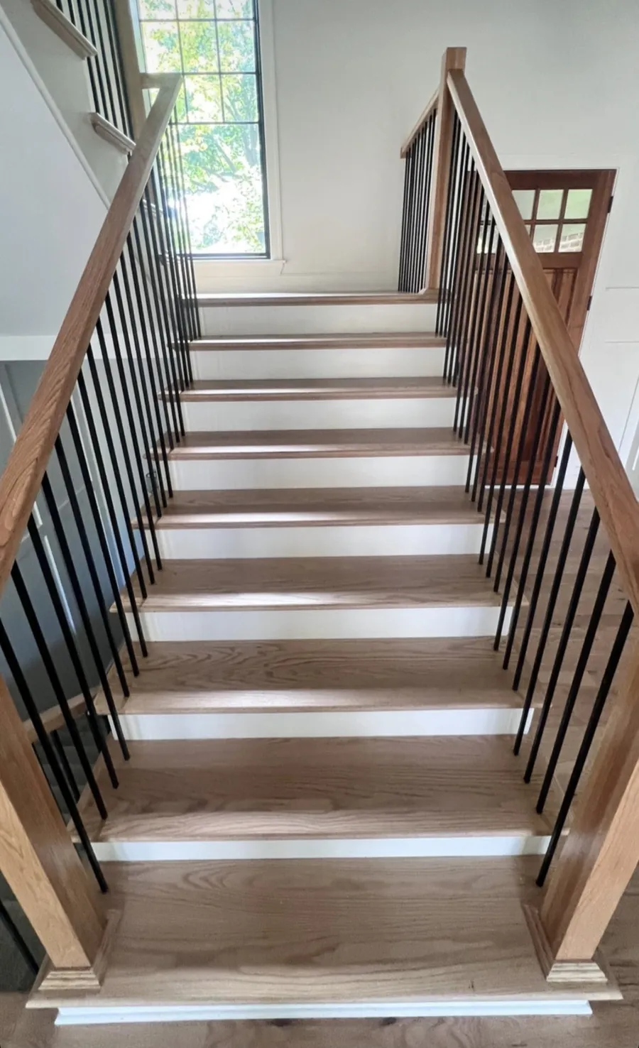 Oak stair treads and handrail with black metal balusters