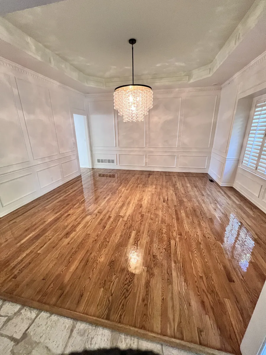 Dining room with a refinished oak floor, wainscoting and a crystal chandelier