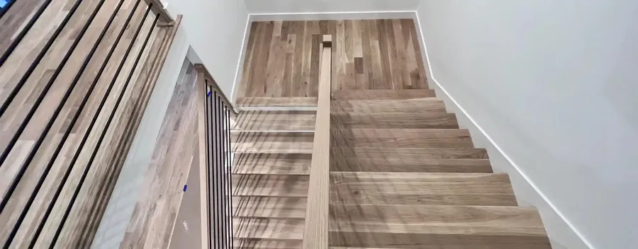 Light oak staircase between white walls