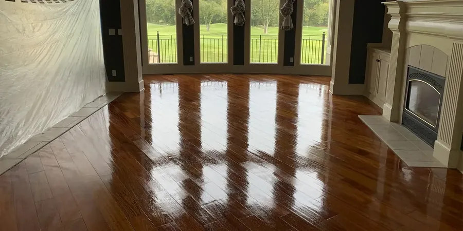 Glossy hardwood in a family room with a fireplace and tall windows