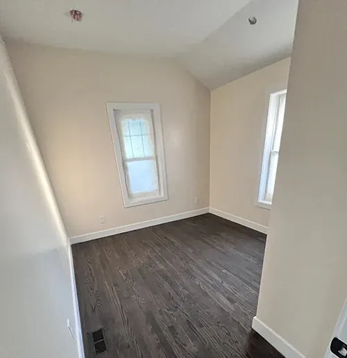 Dark stained hardwood in a bedroom with white trim
