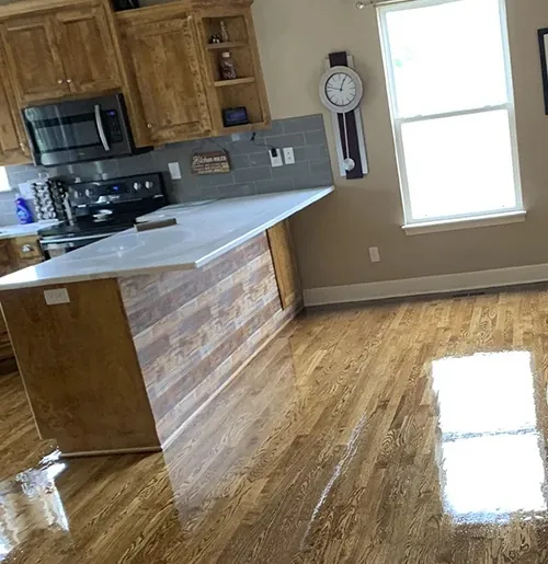 Glossy refinished oak floor in a kitchen with wood cabinets