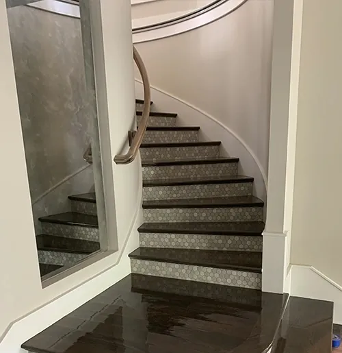 Spiral staircase with dark stained treads and a curved landing